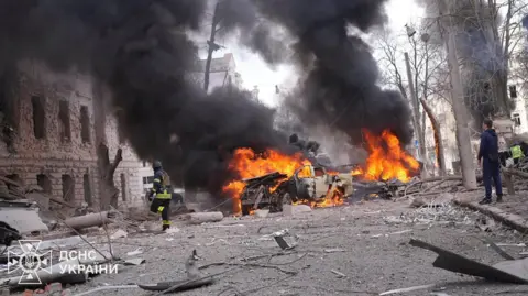 State Emergency Service of Ukraine A handout photo made available by the State Emergency Service of Ukraine (SES) shows Ukrainian rescuers working at the site of a rocket strike in downtown Sumy