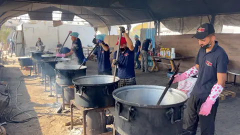 BBC Cooks stir pots of rice and lentils at a community food kitchen run by the US-based humanitarian organisation Anera in Khan Younis, southern Gaza